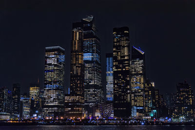 Illuminated buildings against sky at night