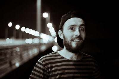 Portrait of surprised man on bridge at night