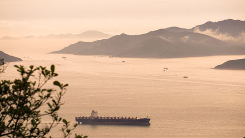 Hong kong cargo ship nuatical transportation  vessel ocean beautiful sunset mountain landscape