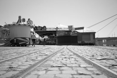 Railroad tracks by buildings against clear sky