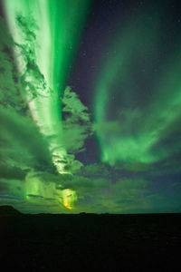 Illuminated landscape against sky at night