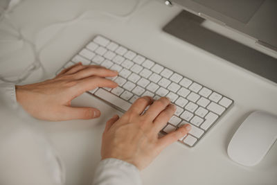 Hands of woman typing on keyboard