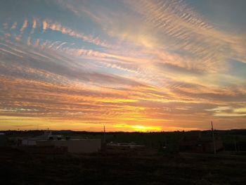 Scenic view of silhouette field against sky during sunset