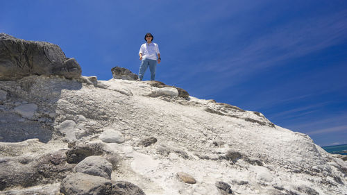 Rear view of man walking on mountain against sky