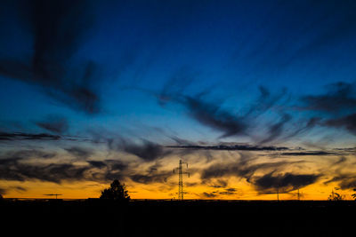 Silhouette of landscape against cloudy sky
