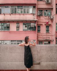 Rear view of woman standing in balcony