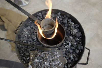 Close-up high angle view of container burning on coal