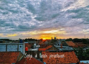 High angle view of buildings in town against sky during sunset