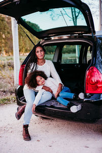 Portrait of a woman sitting on car