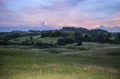 Scenic view of field against sky at sunset
