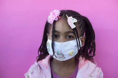 Portrait of cute girl against pink background