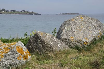 Rocks on sea shore against sky