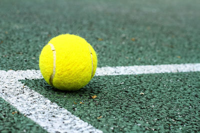 Close-up of yellow ball on tennis court