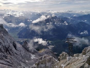 Aerial view of snowcapped mountains against cloudy sky