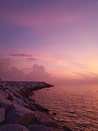 Scenic view of sea against romantic sky at sunset