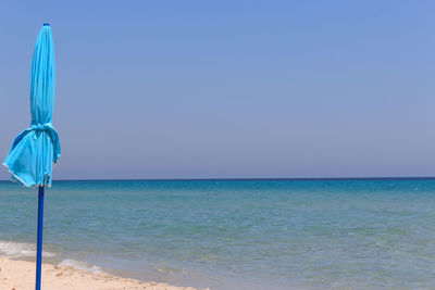 Parasol on beach against clear sky