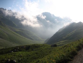 Scenic view of mountains against cloudy sky