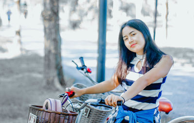 Portrait of young woman with bicycle