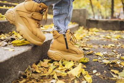 Legs of woman wearing brown shoes moving down on steps