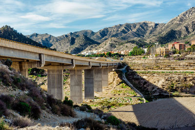 Bridge over mountains against sky