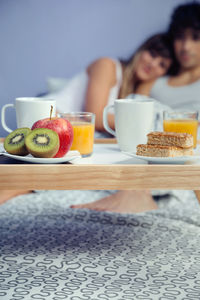 Couple with breakfast on bed at home