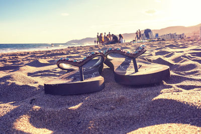 Close-up of deck chairs on beach against sky