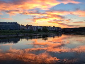 Reflection of buildings in lake during sunset