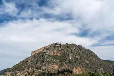 Low angle view of rocks on mountain against sky