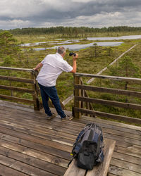 Rear view of woman walking on wooden bench