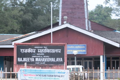 Information sign on built structure against trees