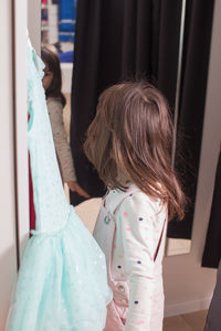 Rear view of girl standing at home