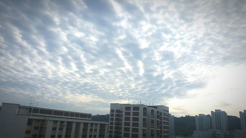 Low angle view of buildings against cloudy sky
