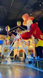 People in illuminated amusement park