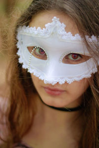 Close-up portrait of young woman wearing venetian mask