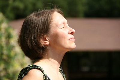 Side view of smiling woman with eyes closed 