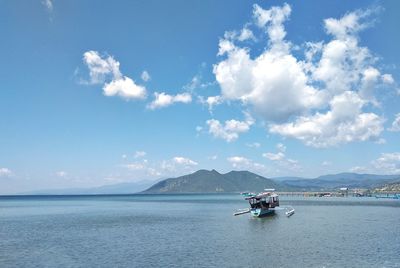 People sailing on sea against sky