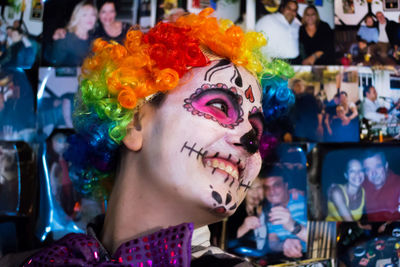 Close-up of woman with spooky halloween make-up against photographs