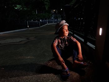 Full length of boy looking away while standing at night