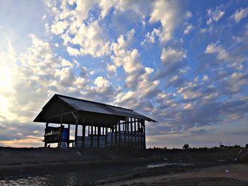 Lifeguard hut on beach against sky during sunset