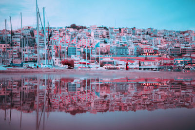 Reflection of buildings in lake against sky