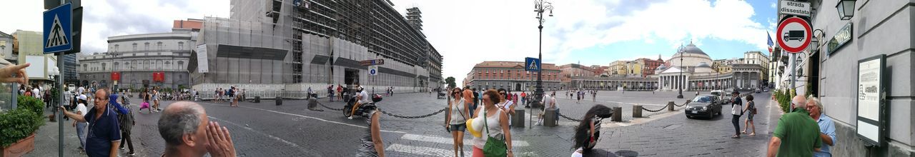 Panoramic view of people on street in city