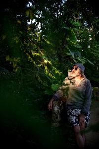 Full length of man standing by tree in forest