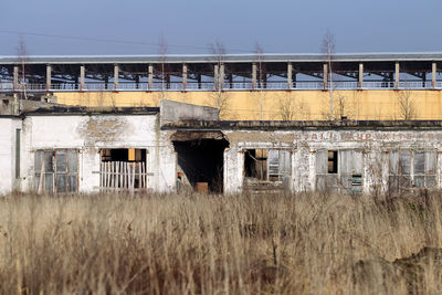 Damaged building on field against sky