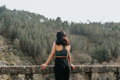 Rear view of woman standing against mountain