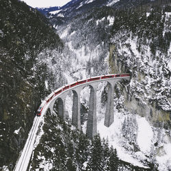 Aerial view of train over bridge during winter