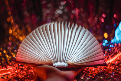 Close-up of hand holding illuminated lighting equipment at night