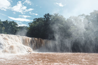 Scenic view of waterfall against sky