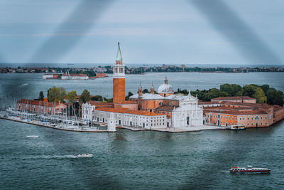 View of buildings at waterfront against sky