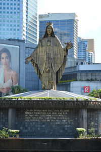 Statue of woman with city in background