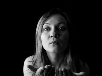 Portrait of a beautiful young woman over black background